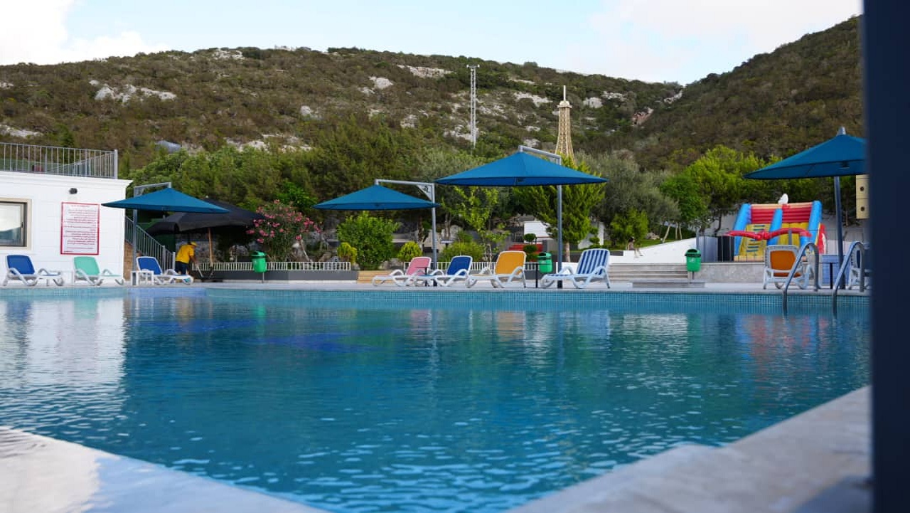 حمام سباحة خارجي بإضاءة ليلية ساحرة في منتجع التلال